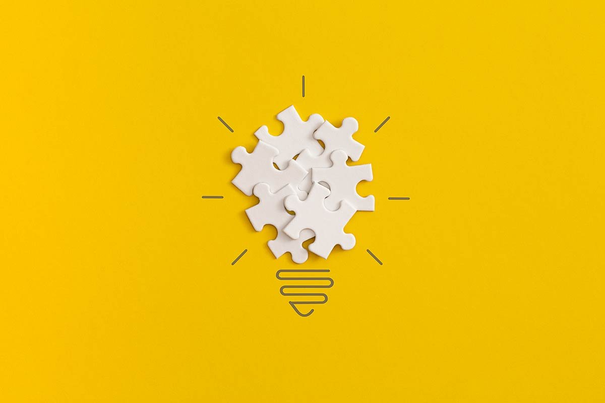 A light bulb made from white puzzle pieces